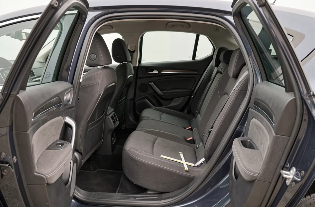 Habitabilité intérieure de la Renault Megane 2026 avec les portes arrière ouvertes montrant l'espace aux jambes et la hauteur de toit pour les passagers