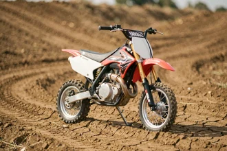 Yamaha PW80 modifiée en moto de cross avec guidon rehaussé et pneus tout-terrain sur piste en terre