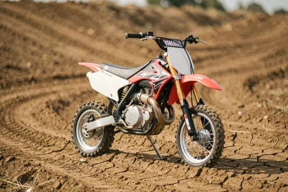 Yamaha PW80 modifiée en moto de cross avec guidon rehaussé et pneus tout-terrain sur piste en terre